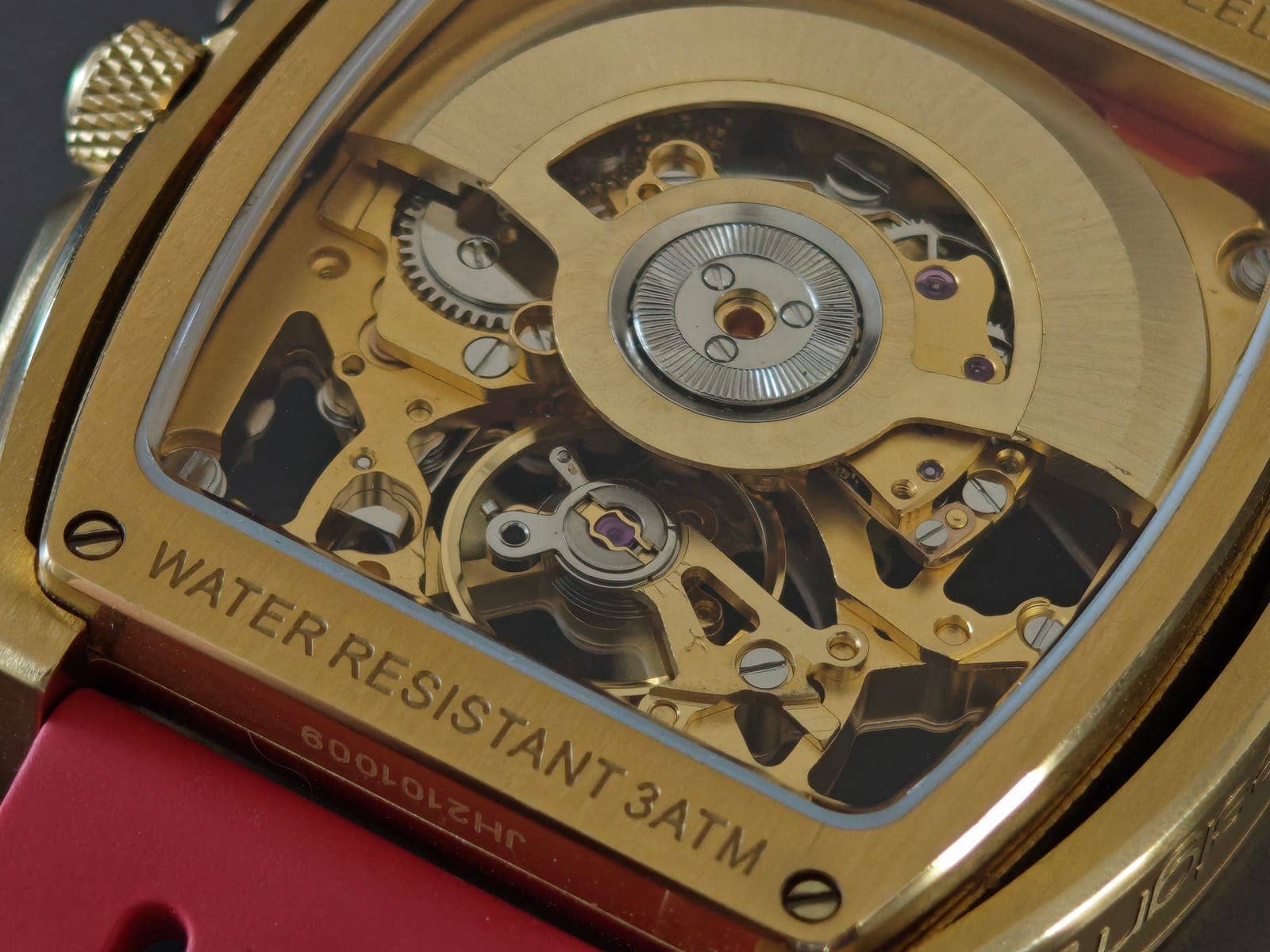 El fondo de exhibición: rotor dorado, volante batiendo y el grabado Water Resistant 3 ATM en el acero