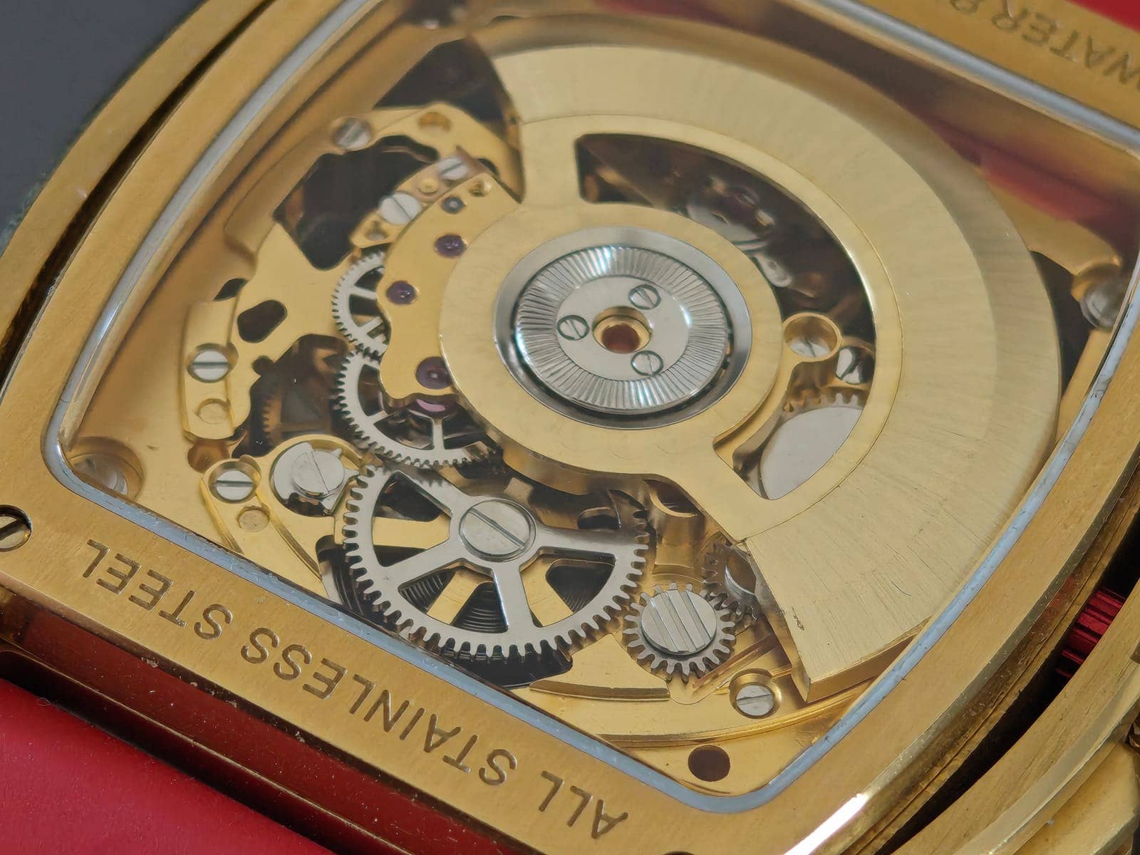El calibre Seagull ST2553JK desde el fondo: rueda de trinquete, engranajes plateados y el grabado All Stainless Steel