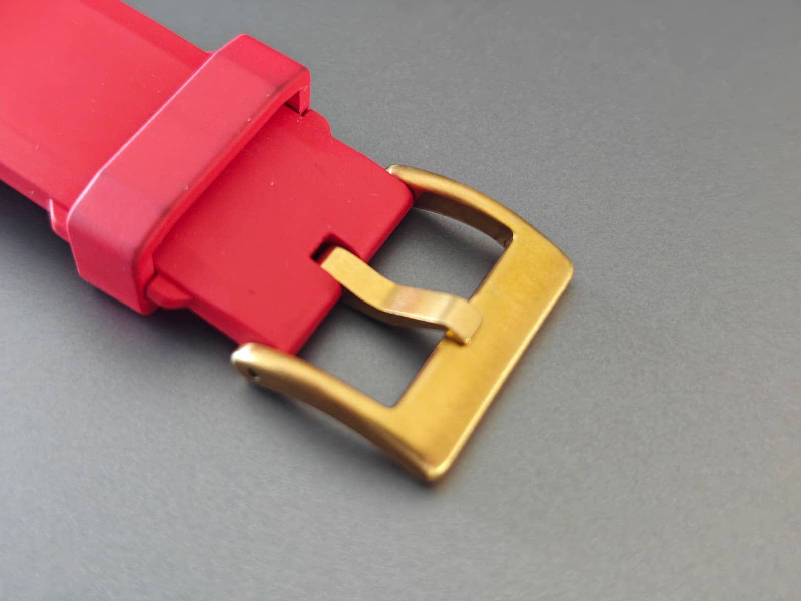 La hebilla dorada sobre la correa de silicona roja con cierre rápido del Z-Series Gold
