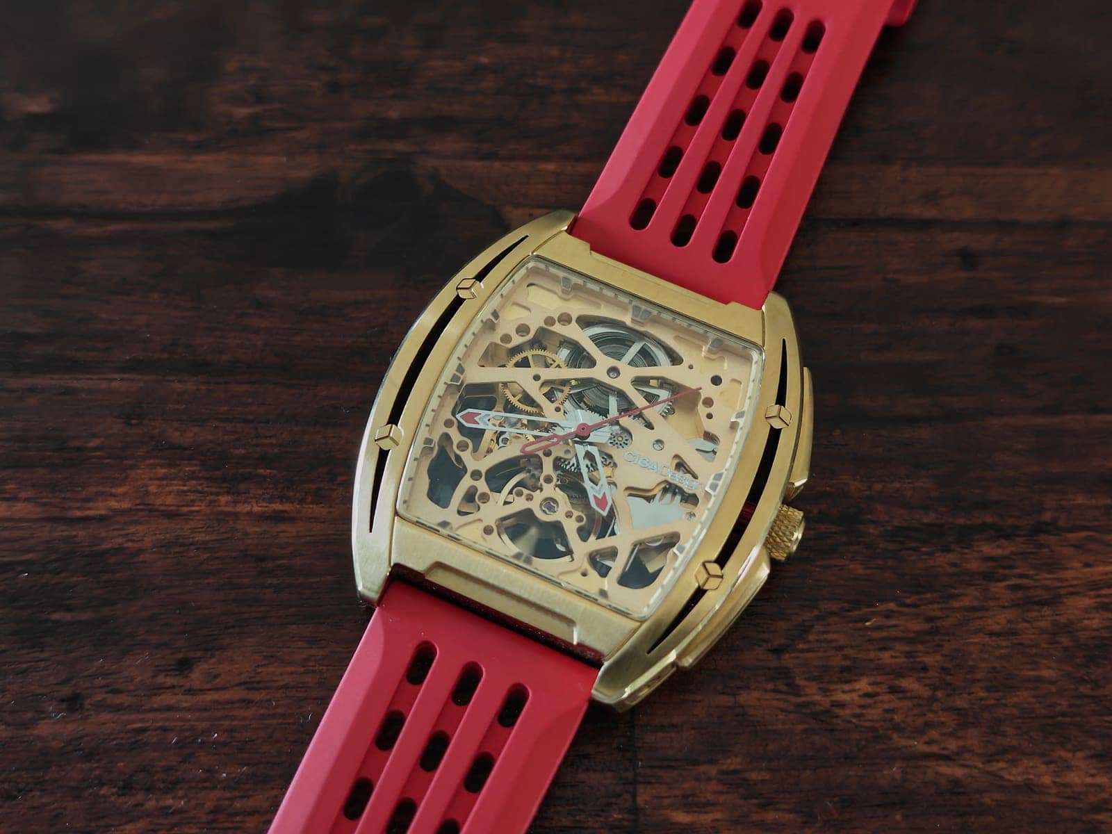 El CIGA Design Z-Series Gold sobre madera oscura: el contraste entre el dorado cepillado y la correa roja de aire racing