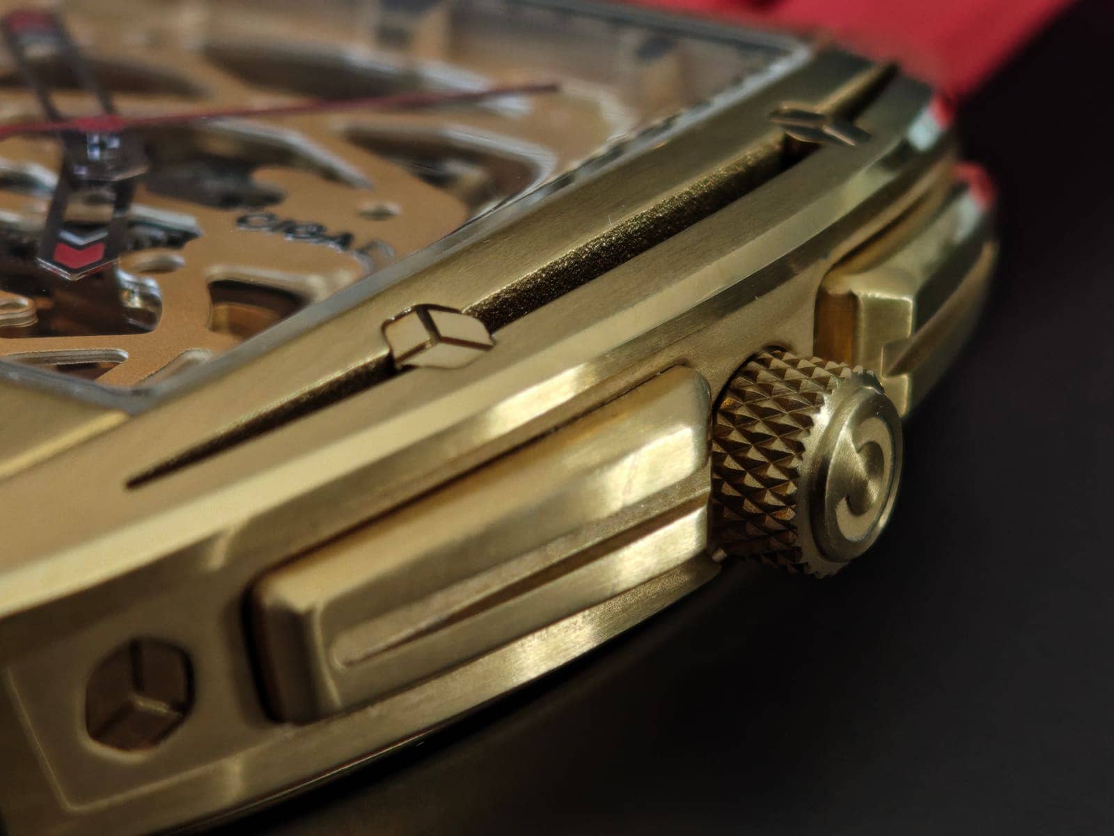 La corona moleteada con el emblema grabado y los protectores esculpidos de la caja tonneau, en dorado cepillado