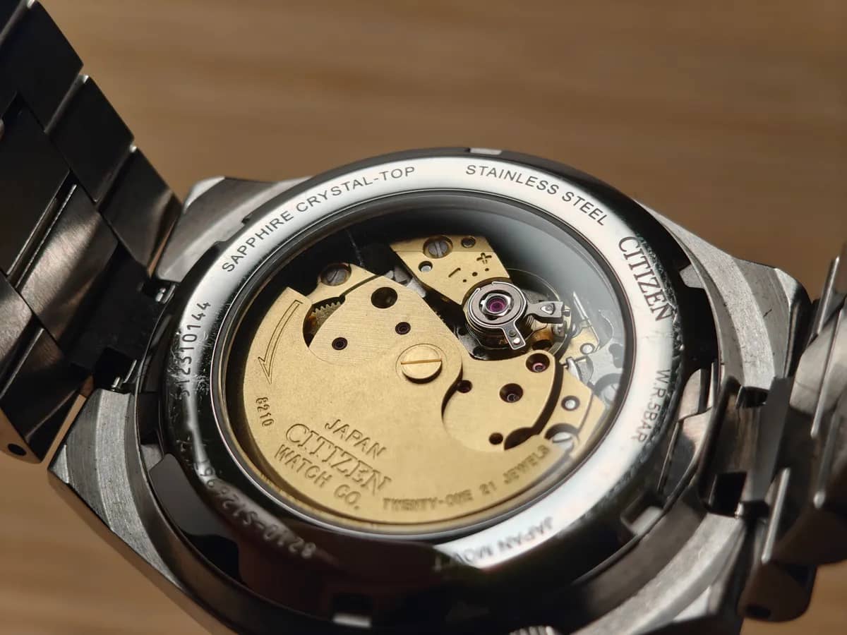 Fondo de exhibición: el calibre automático Citizen 8210 dorado con 21 rubíes y la inscripción «Sapphire Crystal-Top»