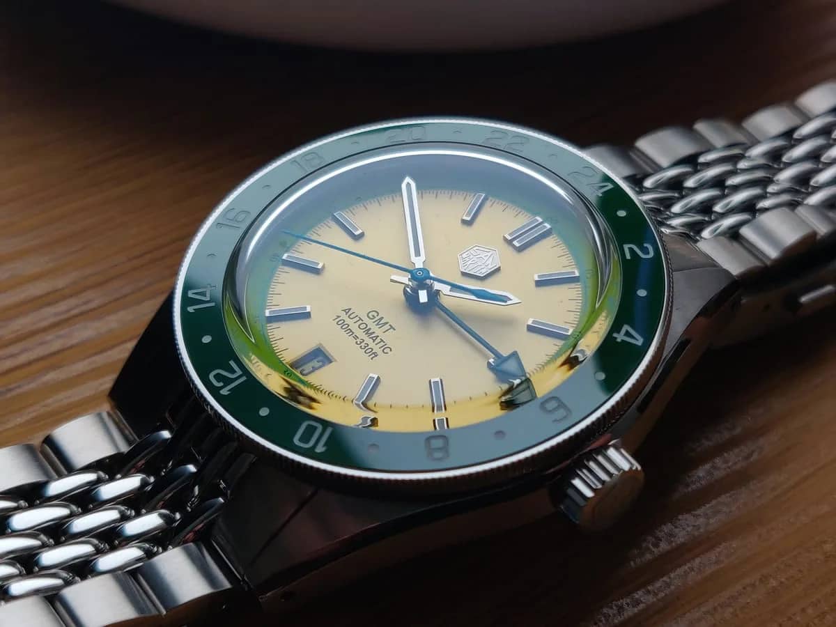 El San Martin SN0116 «Avocado» sobre madera, con el bisel GMT verde y el brazalete beads of rice de acero
