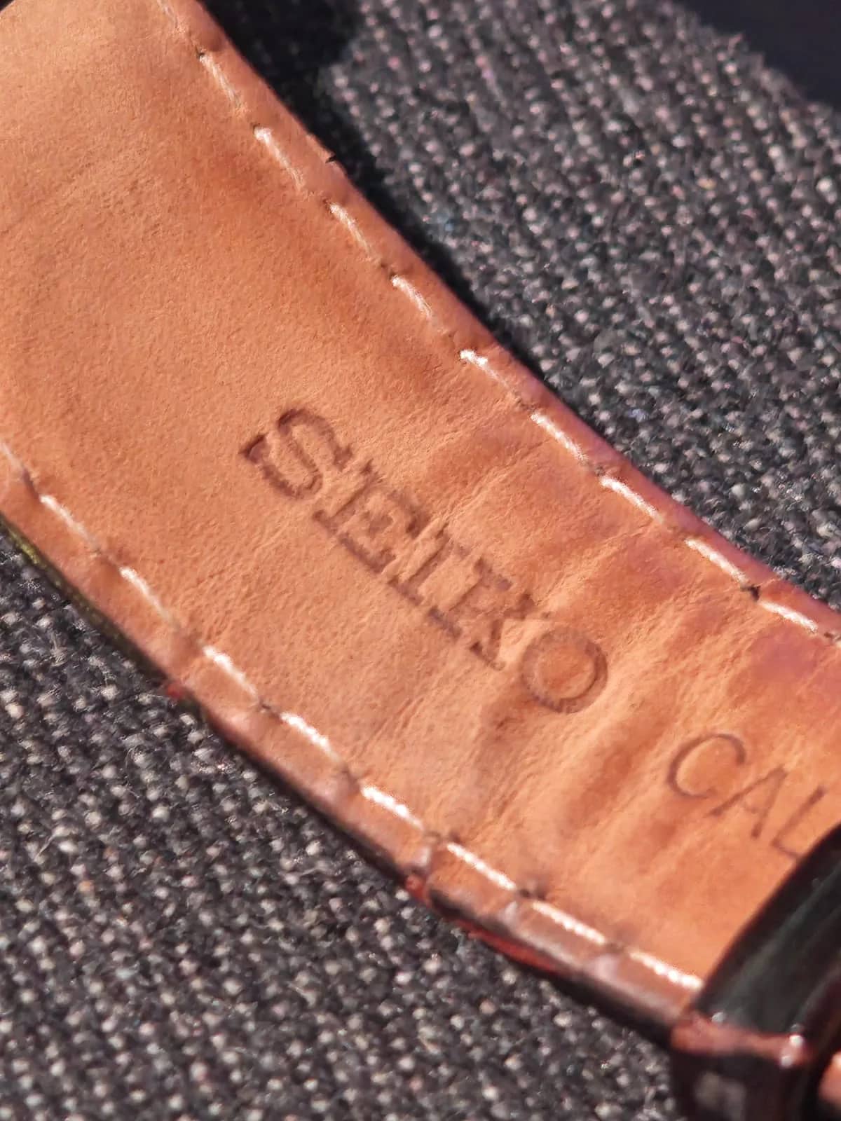 El reverso de la correa de piel de becerro con el sello SEIKO grabado y pespunte a juego
