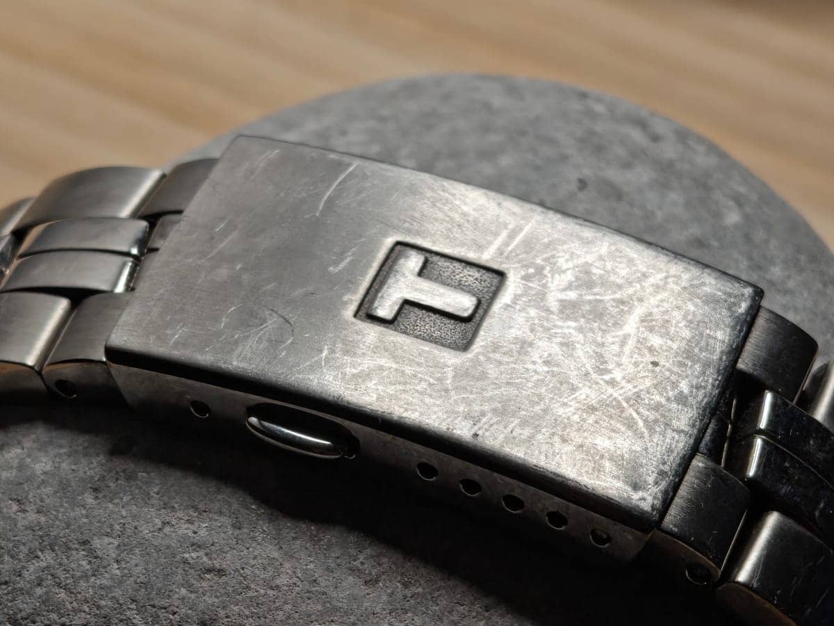 El cierre desplegable de titanio con la T de Tissot grabada, con las marcas honestas de un reloj que se usa a diario