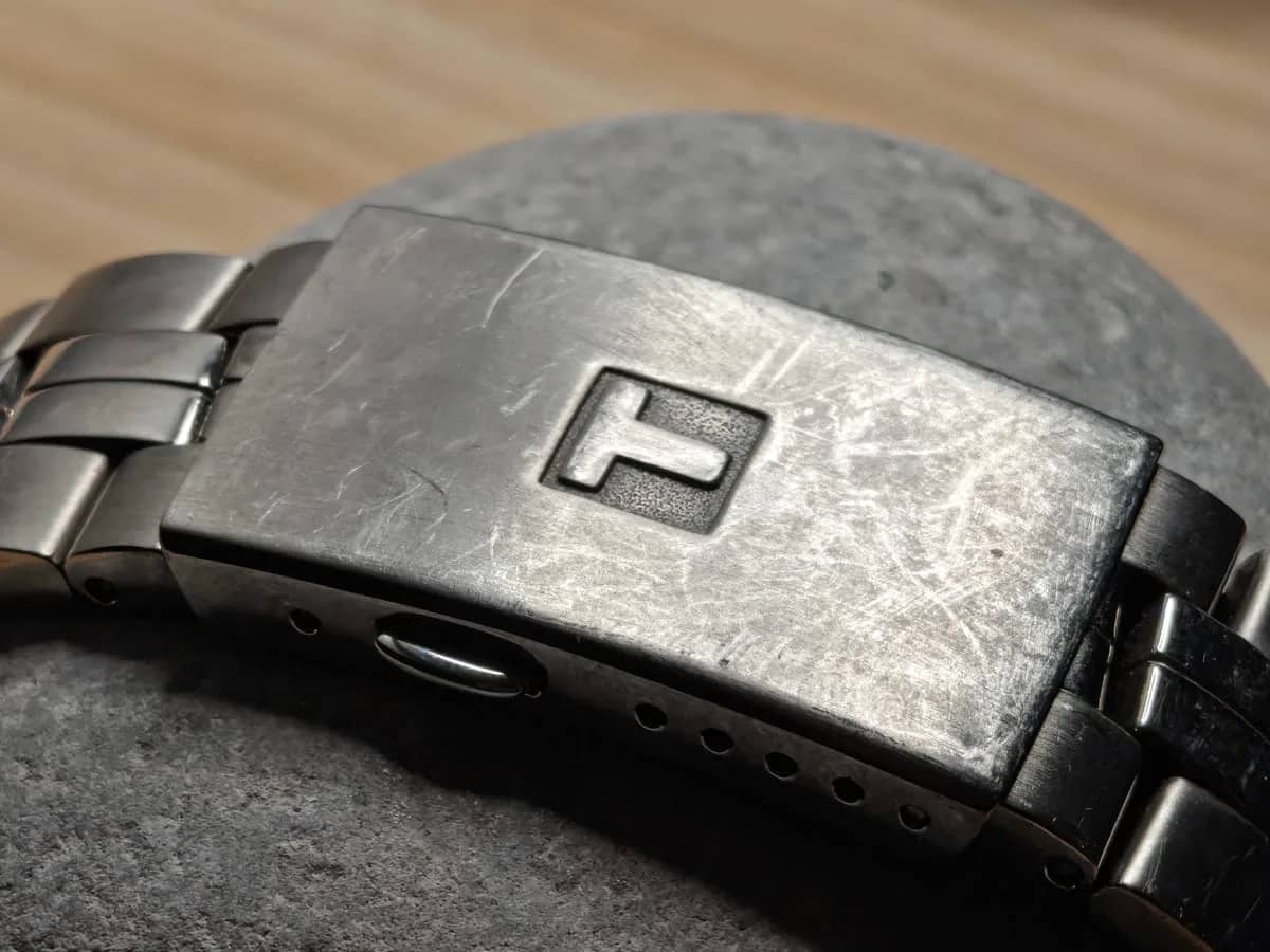 El cierre desplegable de titanio con la T de Tissot grabada, con las marcas honestas de un reloj que se usa a diario