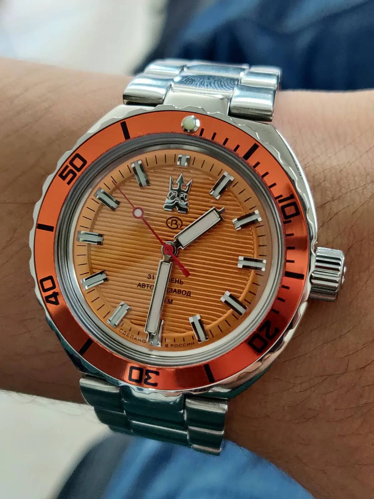 Wrist shot frontal del Neptune 960895: bisel naranja anodizado con perla de lumen y corona firmada a las 3