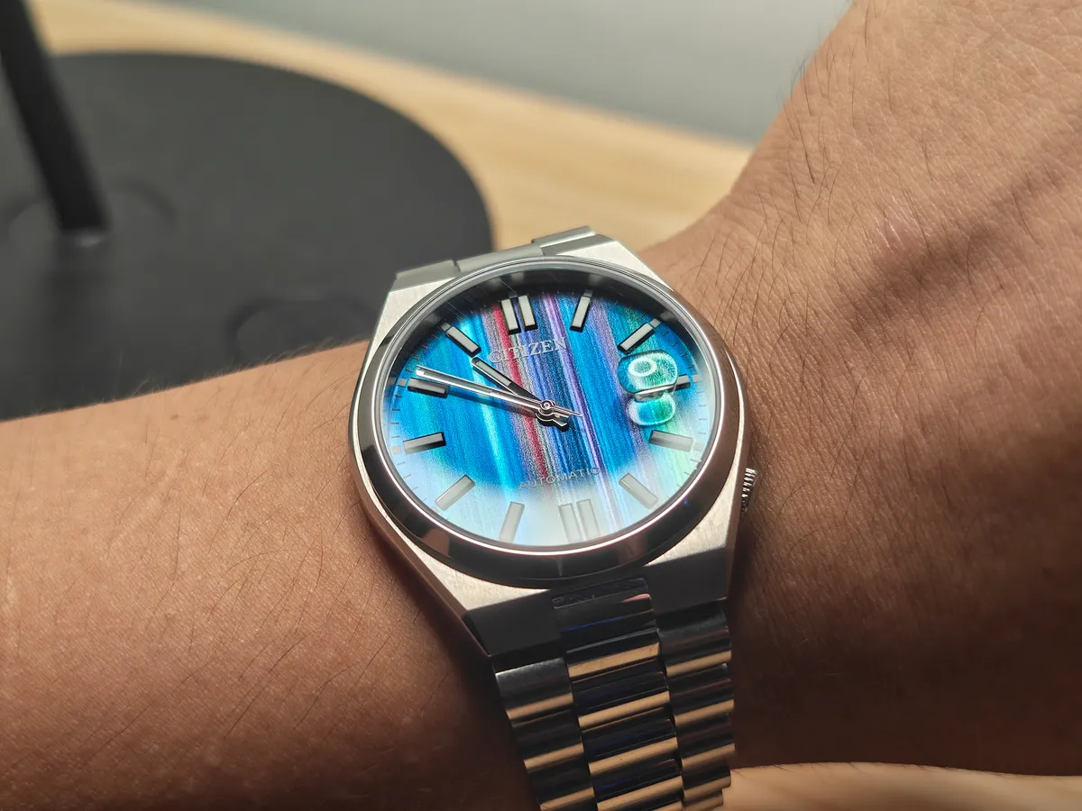 El Citizen Tsuyosa multicolor en la muñeca: el brazalete integrado de acero y la lupa de burbuja sobre la fecha