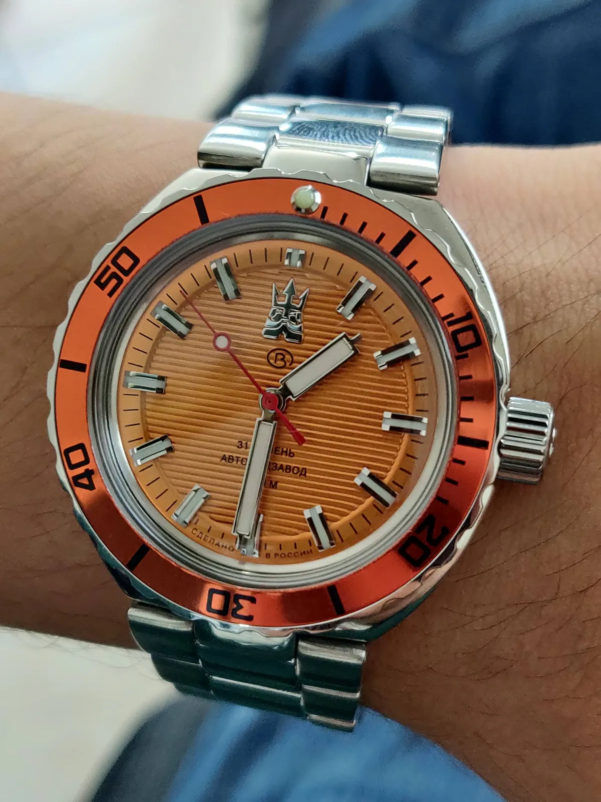 Wrist shot frontal del Neptune 960895: bisel naranja anodizado con perla de lumen y corona firmada a las 3